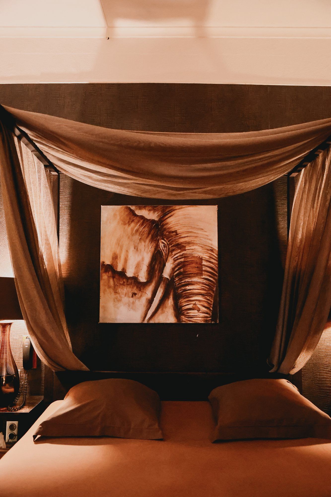 Chambre African Queen de l'hôtel Ô Secret à Liège : lit à baldaquin et tableau éléphant