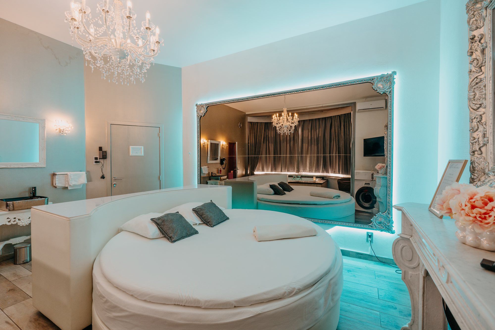 Suite Marie-Antoinette de l'hôtel Ô Secret à Liège : lit rond, lustre en cristal et éclairage d'ambiance